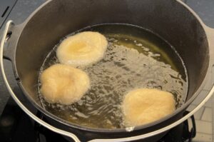 Drei Portionen Pizza Fritta in heißem Öl in Gusseisen-Topf frittieren, goldgelb ausgebacken