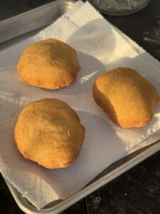 Drei frittierte Pizza-Fritta-Kugeln auf Küchenpapier, golden-braun gefärbt, im Tablett