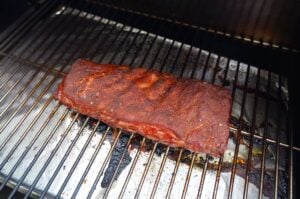 Gewürzter Rippenbrand auf Grillrost, goldbraun angebraten, Zubereitungsschritt für selbstgemachtes McRib-Sandwich