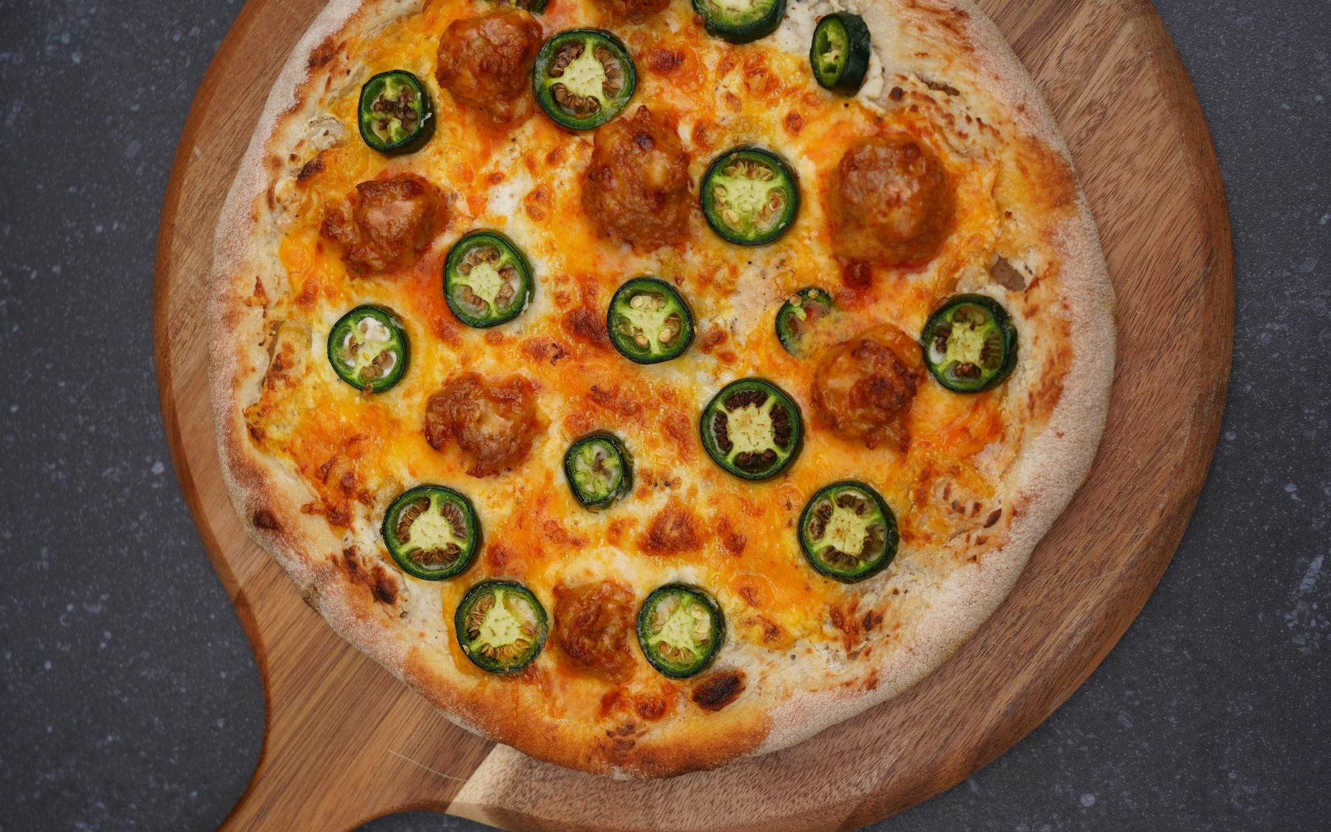 Jalapeno-Popper-Pizza mit geschmolzenem Käse, Pepperoni und frischen Jalapeno-Scheiben auf Holzbrett