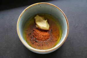 Schüssel mit Öl, Miso-Paste und rotem Paprikapulver für die Miso-Marinade