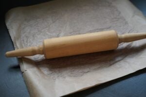 Holzwalker mit Mehl auf Backpapier zur Zubereitung von Döner