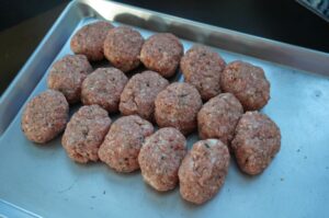 Rohe Frikadellen aus Hackfleisch auf weißem Tablett vor dem Zubereiten in der Heißluftfritteuse