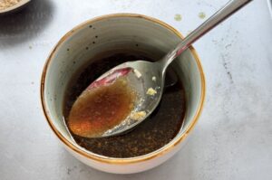 Marinade für Japanischen Krautsalat in Keramikschale mit Löffel, dunkle Sojasauce-Basis-Mischung