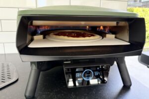 Pizza Marinara im Pizzaofen mit loderndem Feuer, auf Backstein bei etwa 380°C, digitales Temperatur-Steuerungspanel sichtbar