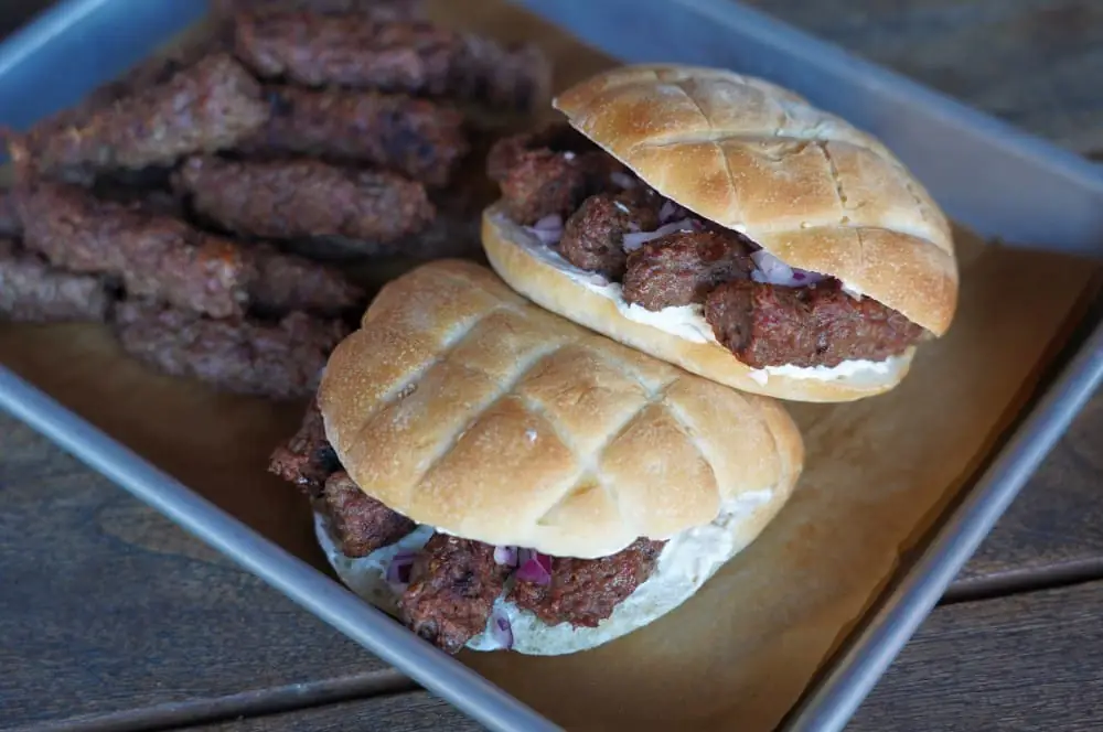 Ćevapčići vom Grill - Rezept für Balkan-Hackfleischröllchen 7 Ćevapčići im Lepinje mit roten Zwiebeln und Kaymak