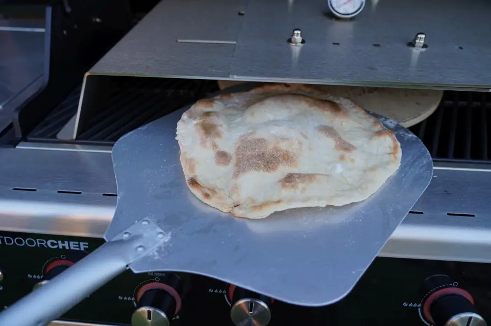 Süße Pizza mit Schokolade, Bananen und Pistazien 3 Der Pizzaboden wird unter dem Moesta-BBQ Pizzacover gebacken