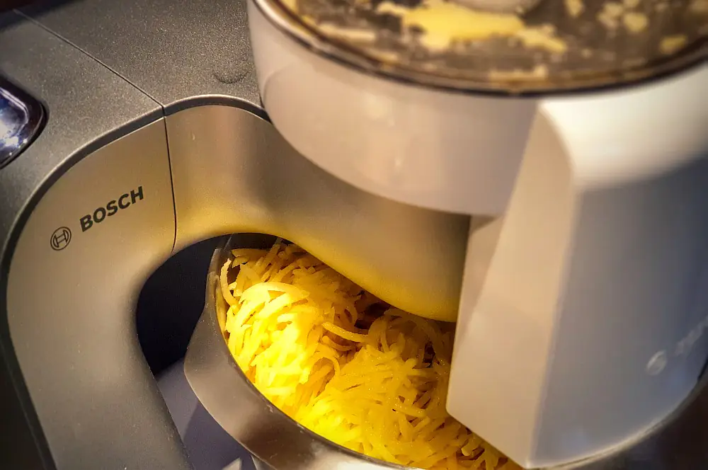 Schweizer Rösti mit Pilzen 2 Die Kartoffeln werden mit der Küchenmaschine fein geraspelt