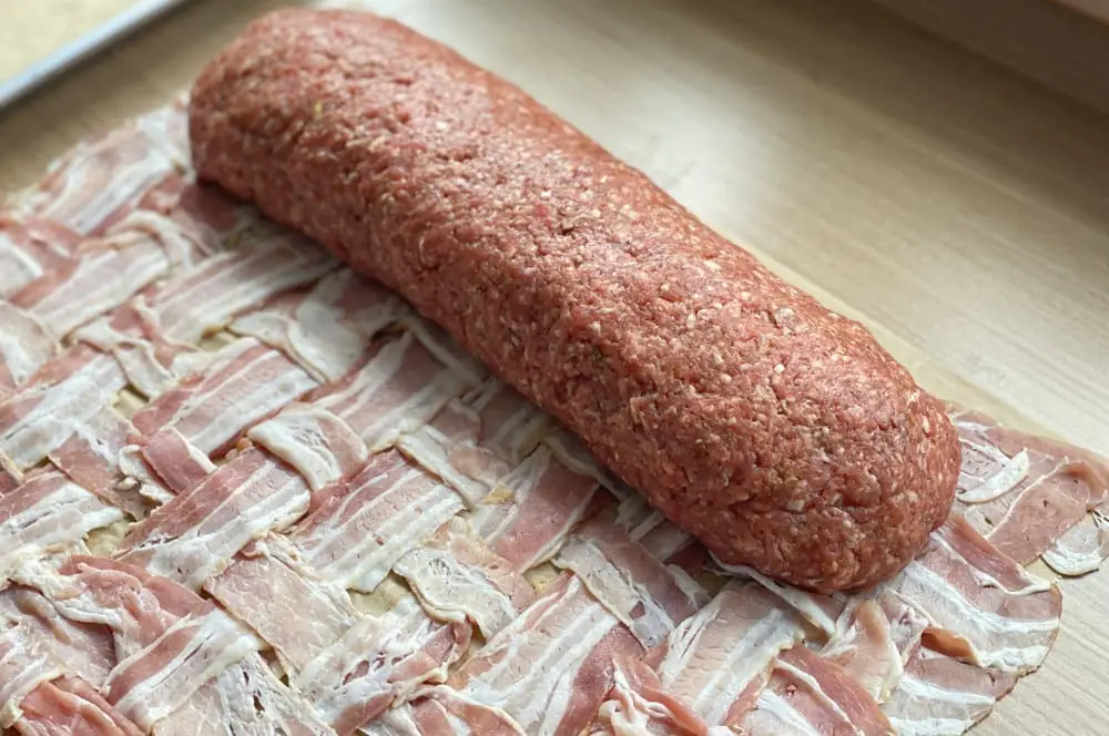 Griechische Bacon Bomb mit Feta, Oliven und getrockneten Tomaten 4 Das Hackfleisch wird aufgerollt und in das Baconnetz gewickelt
