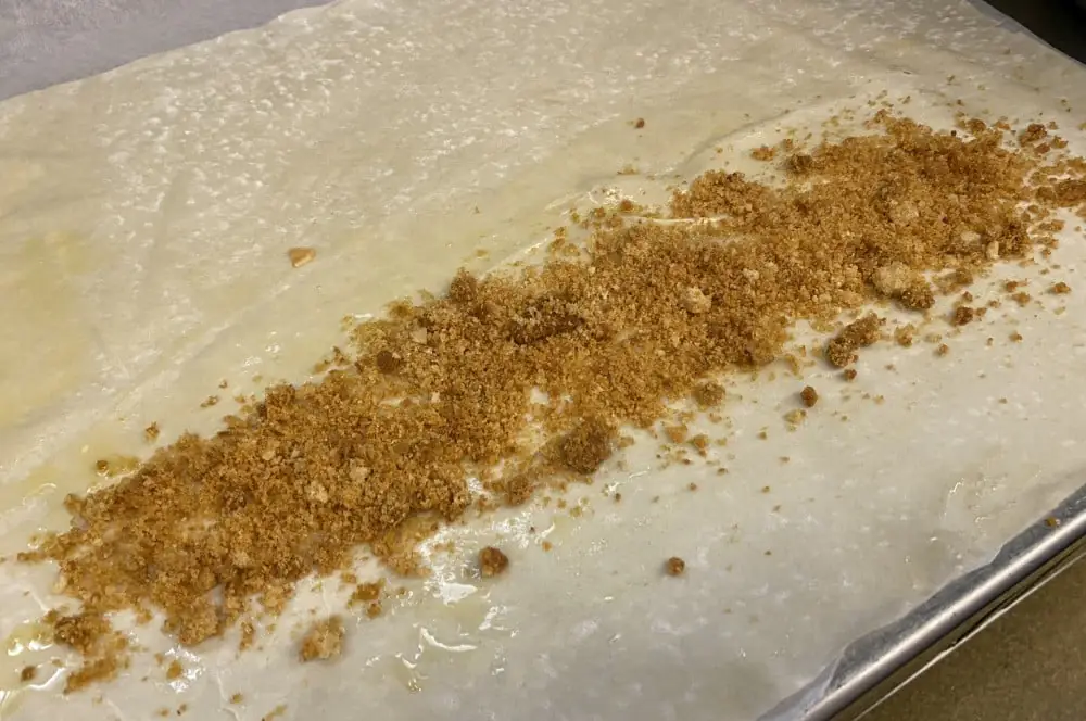 Apfelstrudel - Rezept für den Strudelklassiker aus Österreich 2 Der Strudelteig wird mit Butter bestrichen und mit den Semmelbröseln belegt