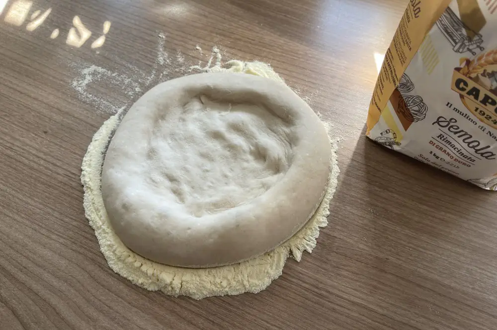 Neapolitanischer Pizzateig - So gelingt er perfekt! 10 Neapolitanischer Pizzateig wird von innen nach außen gedrückt