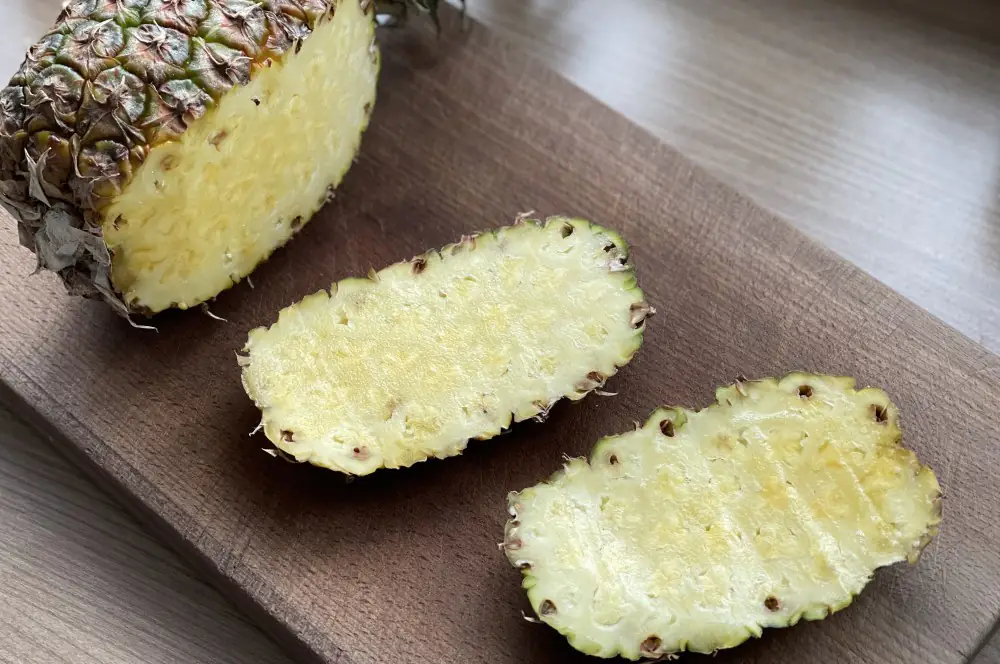 Die Schale wird von der Ananas geschnitten