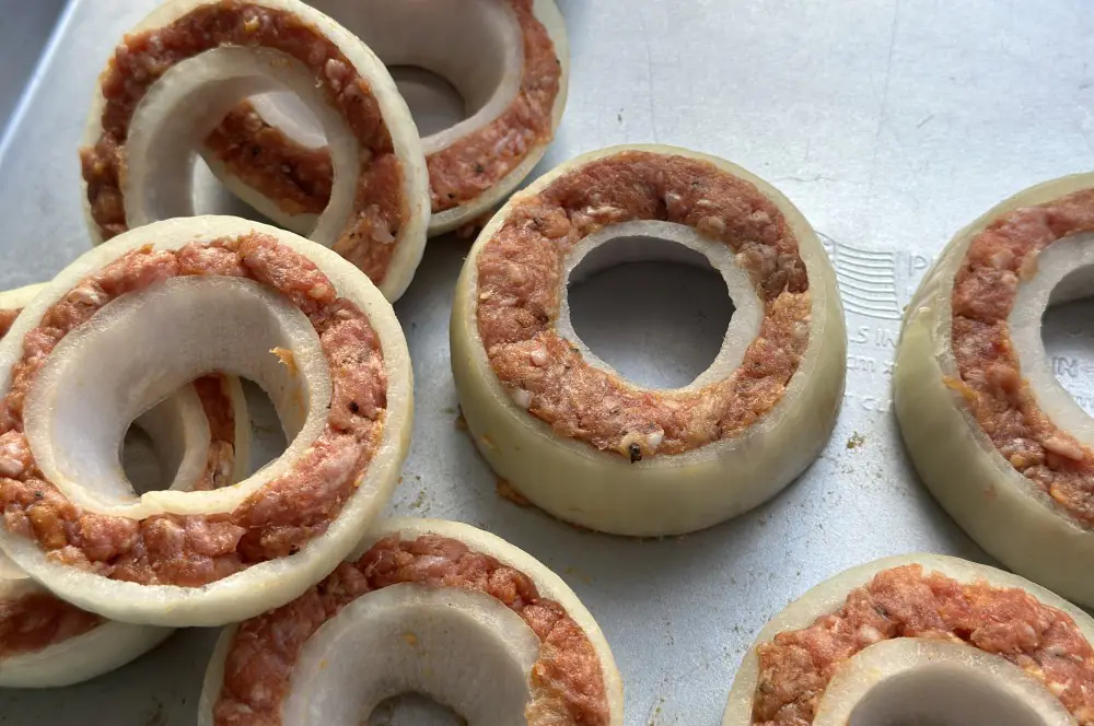 Gefüllte Zwiebelringe mit Hackfleisch und Bacon 3 Das Hackfleisch wird in die Zwiebelringe gefüllt