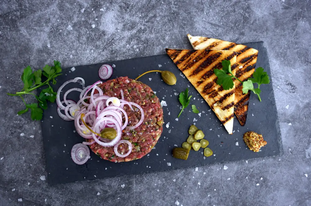 Beef Tatar - Rezept für klassisches Rindertatar mit Kapern 4 Beef Tatar mit Zwiebelringen, Kapernäpfel und Toast