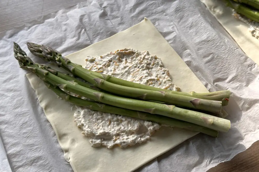 Der Blätterteig wird dem grünen Spargel belegt