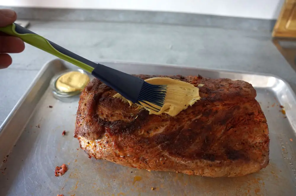 Schweinebraten aus dem Dutch Oven 3 Der angebratene Nacken wird mit Senf bestrichen