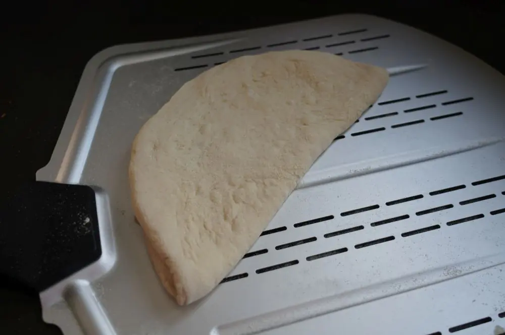 Der Pizzateig wird zusammengeklappt
