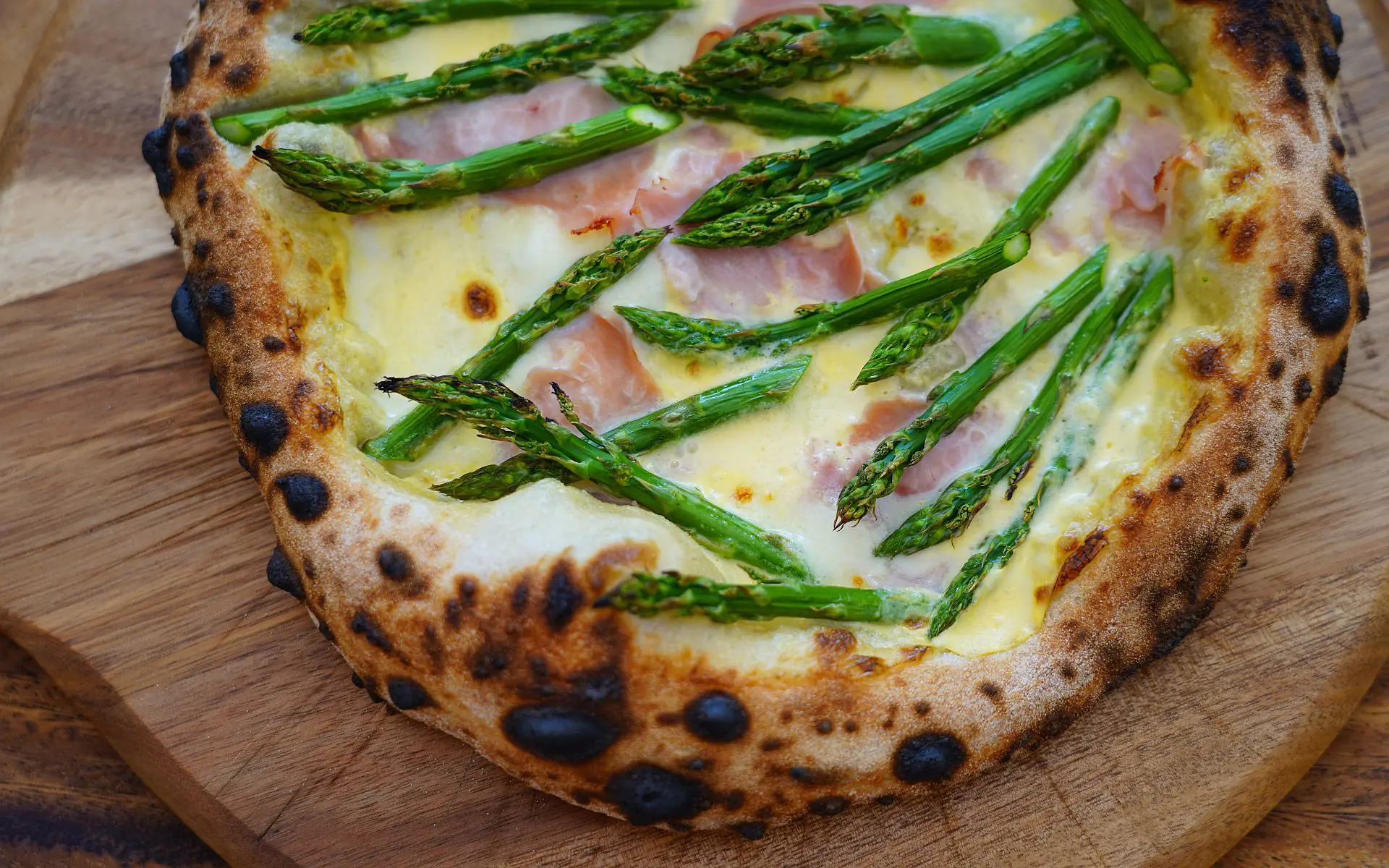 Pizza mit grünem Spargel, Schinken und Sauce Hollandaise