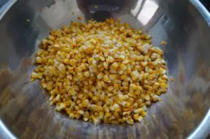 Gekochte Maiskörner mit Salz in einer Metallschüssel für Esquites, mexikanischen Maissalat