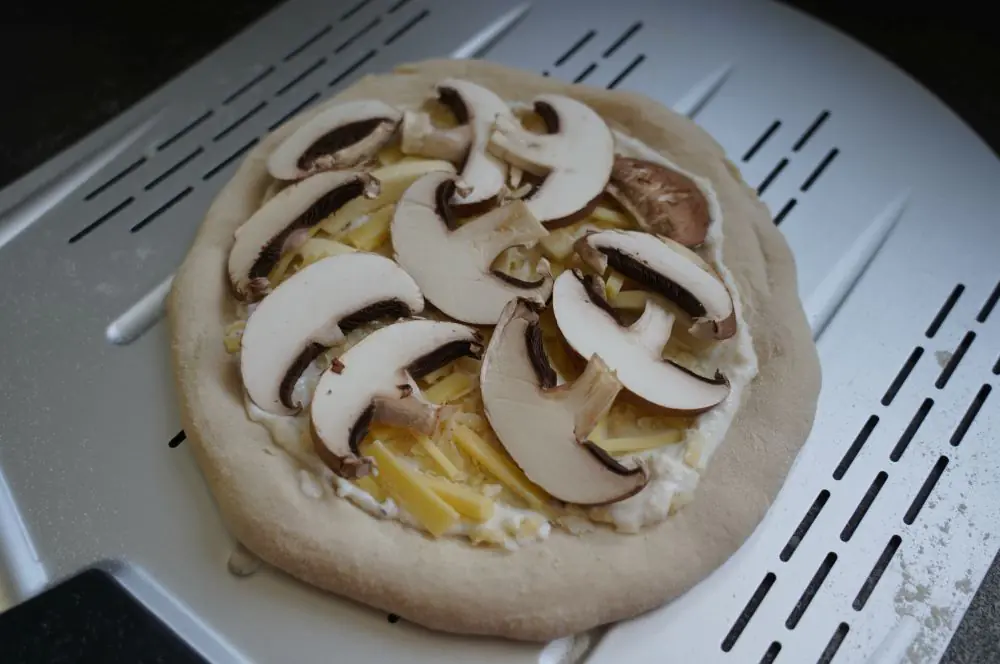 Pizza Ricotta-Champignon mit frischer Zitronen-Ricottacreme 2 Die Pizza Ricotta-Champignon wird belegt