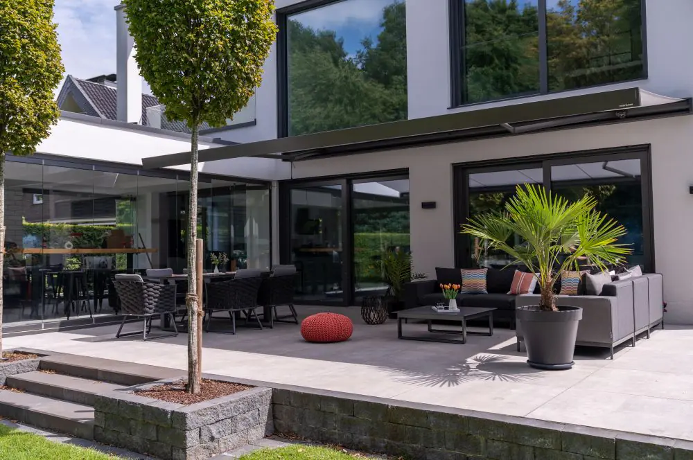 Die Terrassenmarkise schützt das Outdoor-Wohnzimmer vor zu starker Sonneneinstrahlung