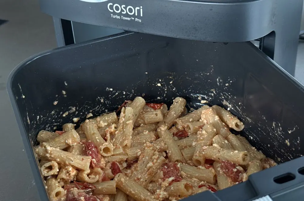 Die heiße Pasta wird mit dem Feta und den Tomaten vermengt