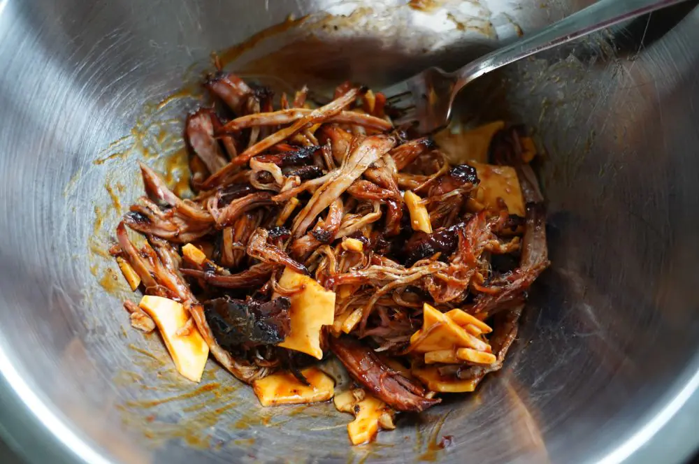 Das Pulled Pork wird mit BBQ-Sauce und Käse vermengt