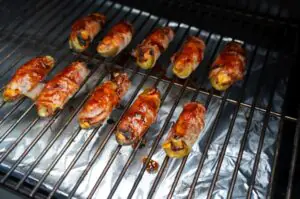 Bacon-umwickelte Pickle-Spears auf dem Grill mit karamellisierter Oberfläche und Grill-Markierungen