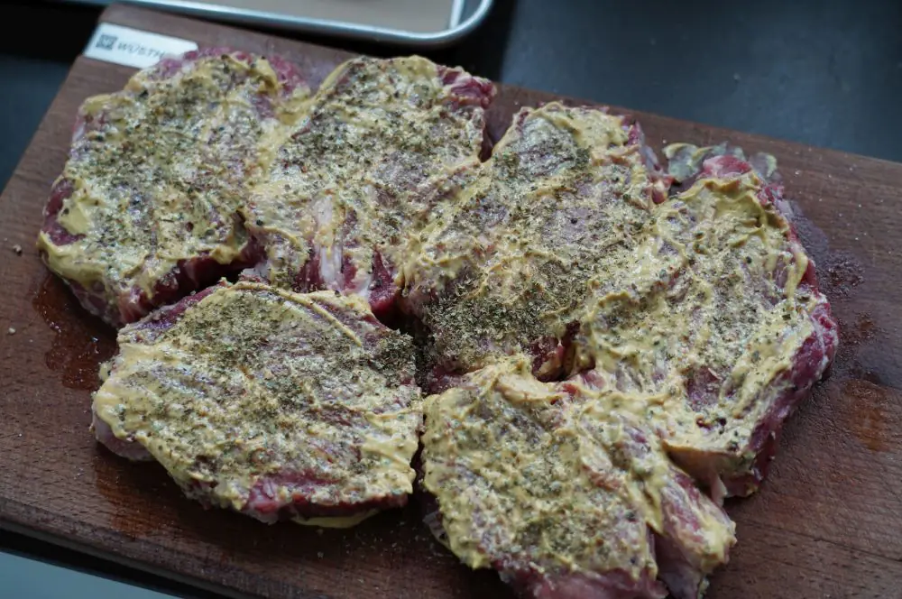 Die Nackensteaks werden mit Senf eingerieben