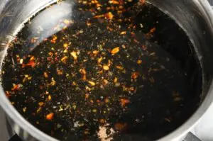 Glasierte Yakitori-Sauce mit gehacktem Knoblauch und Chili in einem Topf