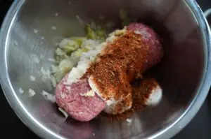 Hackfleisch mit Zwiebeln und Gewürzen in Metallschüssel, Zutaten für Backpapier-Döner