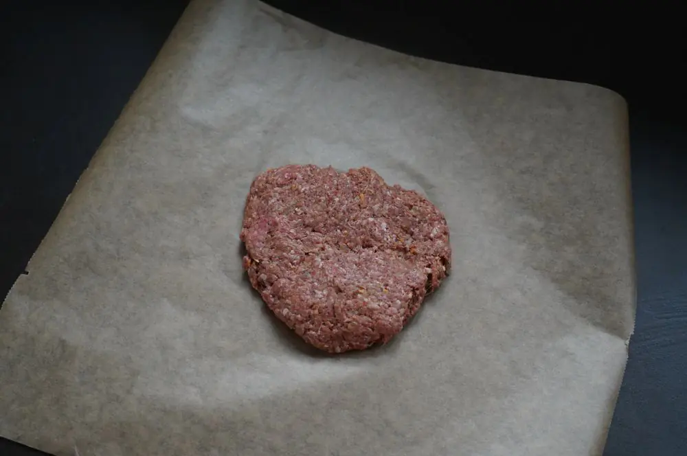 Die Hackfleischmasse wird auf das Backpapier gegeben