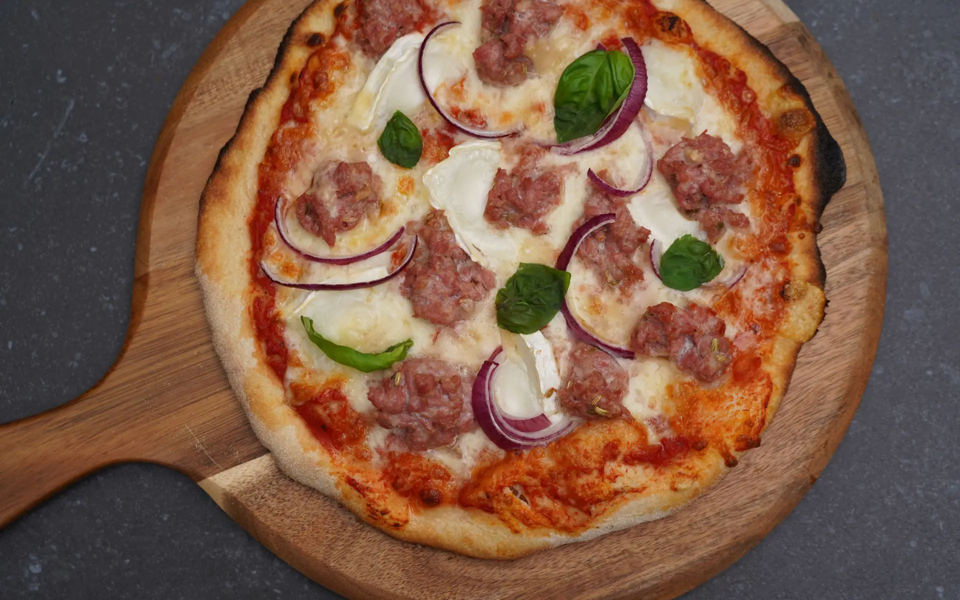 Salsiccia-Pizza mit Ziegenkäse und roten Zwiebeln
