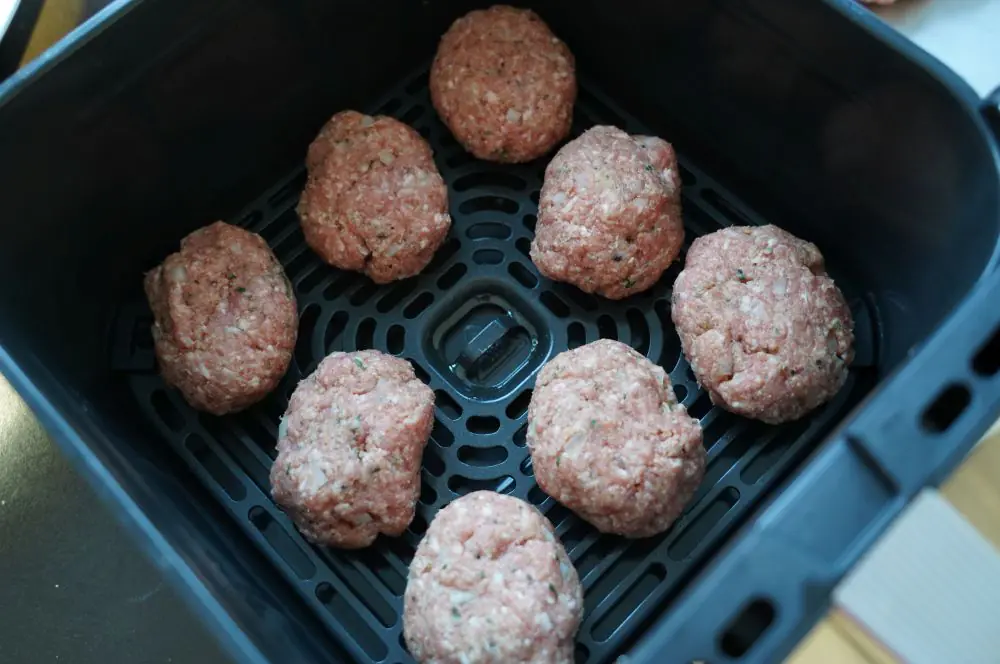 Die Frikadellen werden im Korb der Heißluftfritteuse platziert