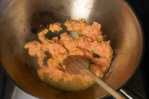 Gemahlenes Schweinefleisch wird in einem Wok mit Gewürzen und Chili angebraten, Zutat für Pad Kra Pao
