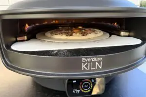 Pizza Carbonara mit Spiegelei in Everdure KILN Pizzaofen bei 513°C, oben auf Pizzastein, Flammen sichtbar