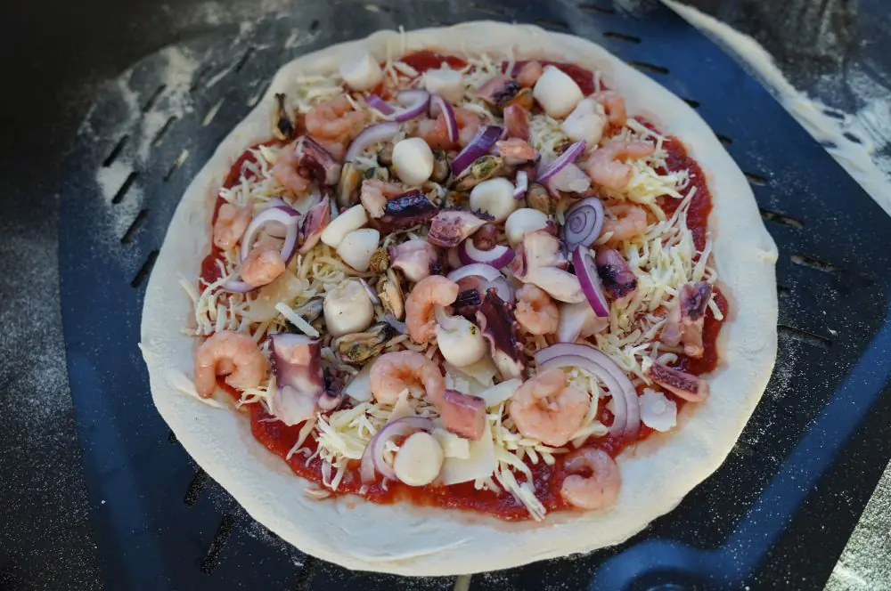 Die Meeresfrüchte-Pizza wird belegt