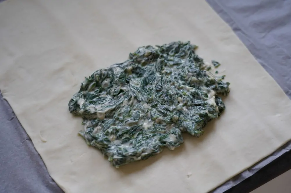 Die Frischkäse-Spinatmischung wird auf dem Blätterteig verteilt