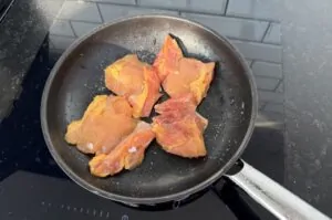 Maishähnchen-Pizza mit Pollo Fino und Mais 7 Hähnchenbrustfilets werden in einer schwarzen Pfanne auf dem Grill angebraten