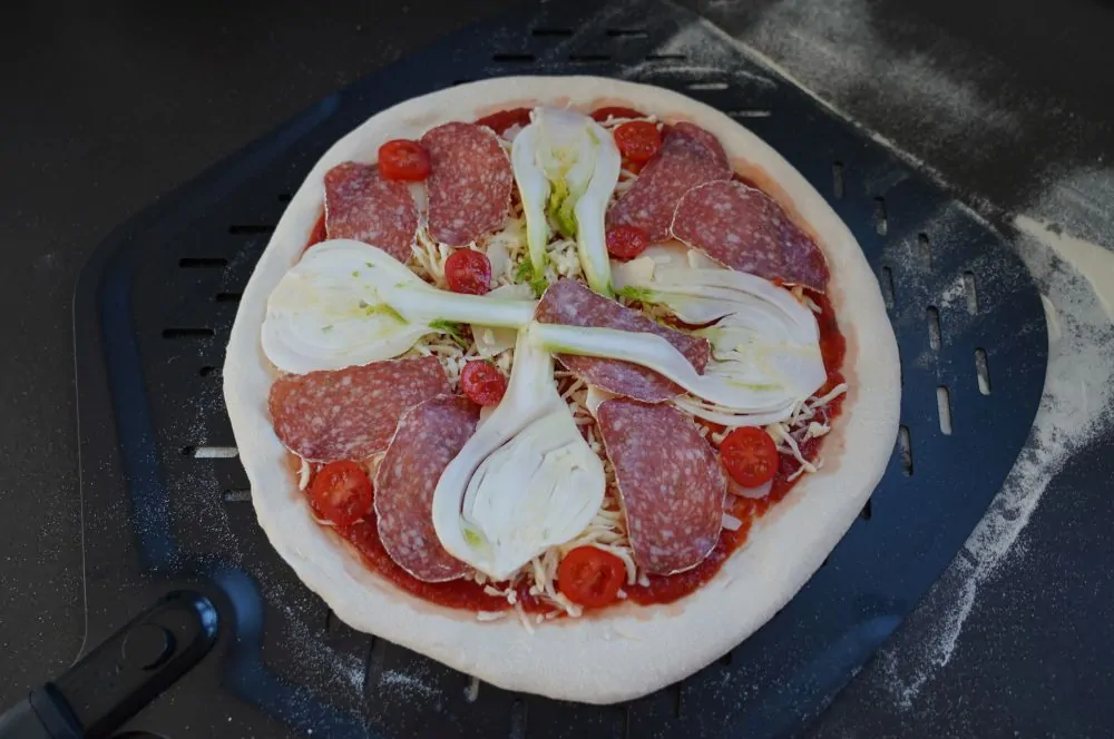 Die Fenchel-Pizza wird belegt