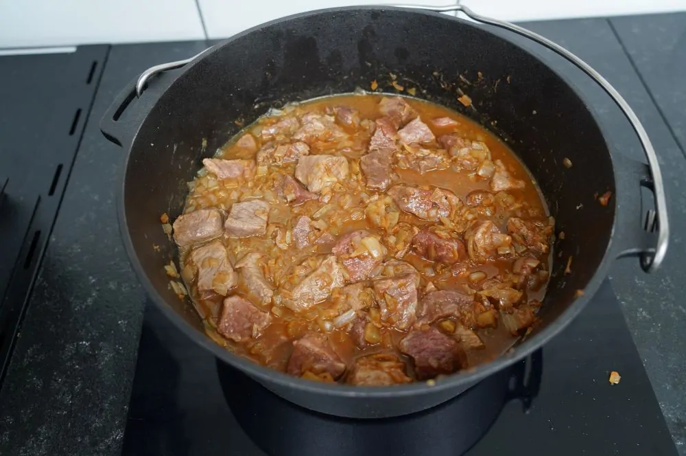 Das Gulasch wird mit Brühe angegoßen