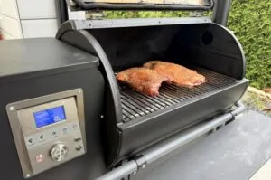 Zwei Wildschwein-Ribs mit Raucharoma auf dem Grillrost eines Pelletgrills bei 105°C, digitales Kontrolltermometer sichtbar