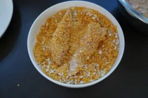 Gewürzmischung mit Paniermehl, Paprika und Knoblauch in weißer Schüssel für Chicken Fingers