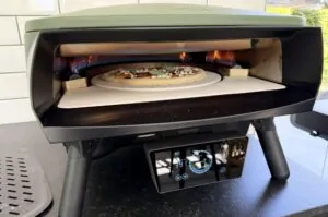 Kürbispizza mit Speck und Salbei 8 Elektro-Pizzaofen mit Kürbispizza belegt mit Speck und Salbei auf dem Pizzastein bei Feuer im Ofen
