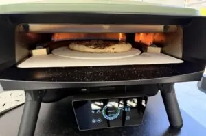 Currywurst-Pizza mit Flammkuchen und Tomatensauce in elektrischem Pizza-Ofen bei 480°C mit aktiver Gasflamme auf Pizzastein