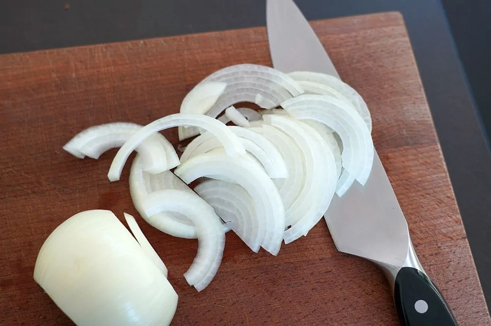 Die Zwiebeln werden in halbe Ringe geschnitten
