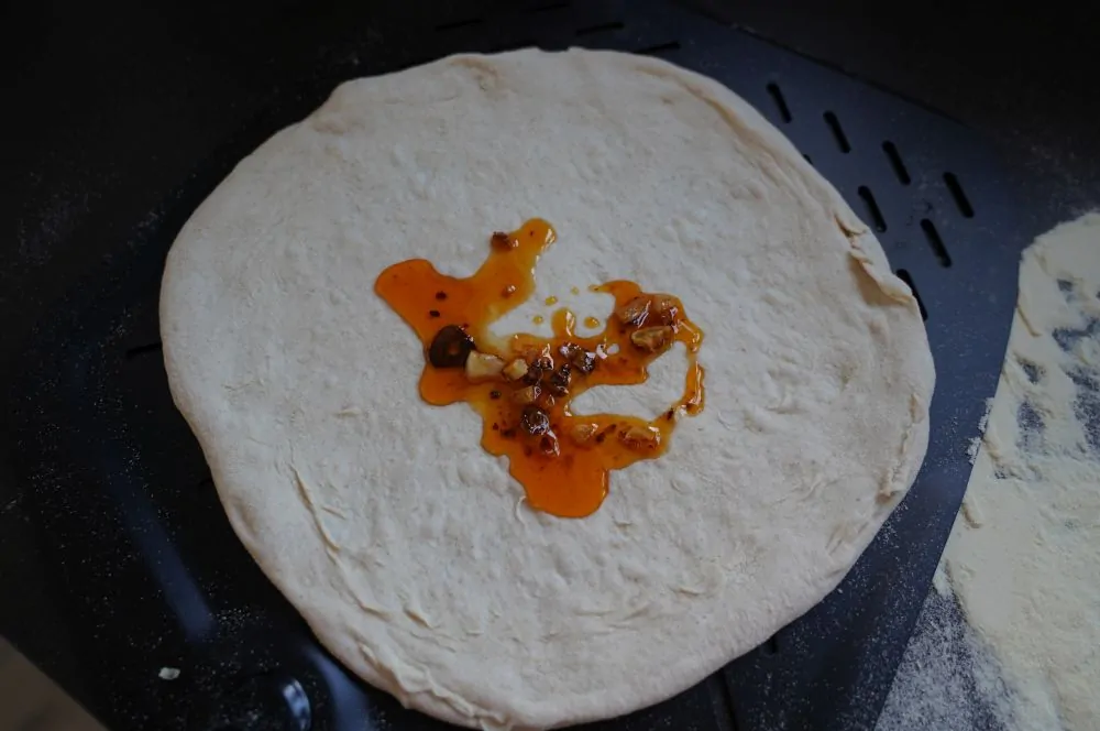 Das Öl wird auf dem Pizzateig verteilt