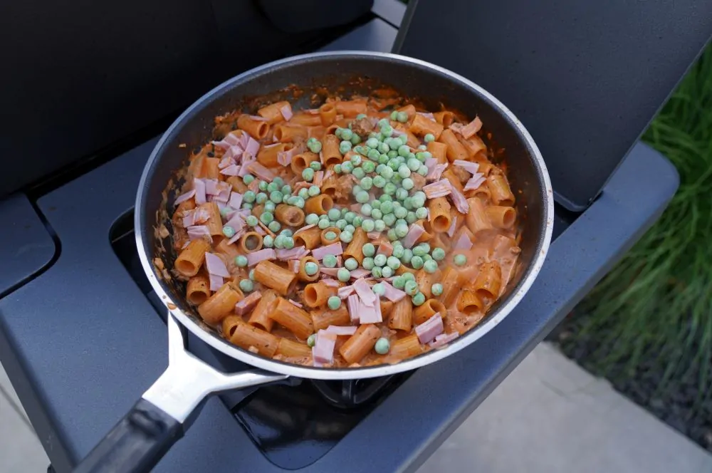 Schinken und Erbsen werden mit in die Sauce gegeben