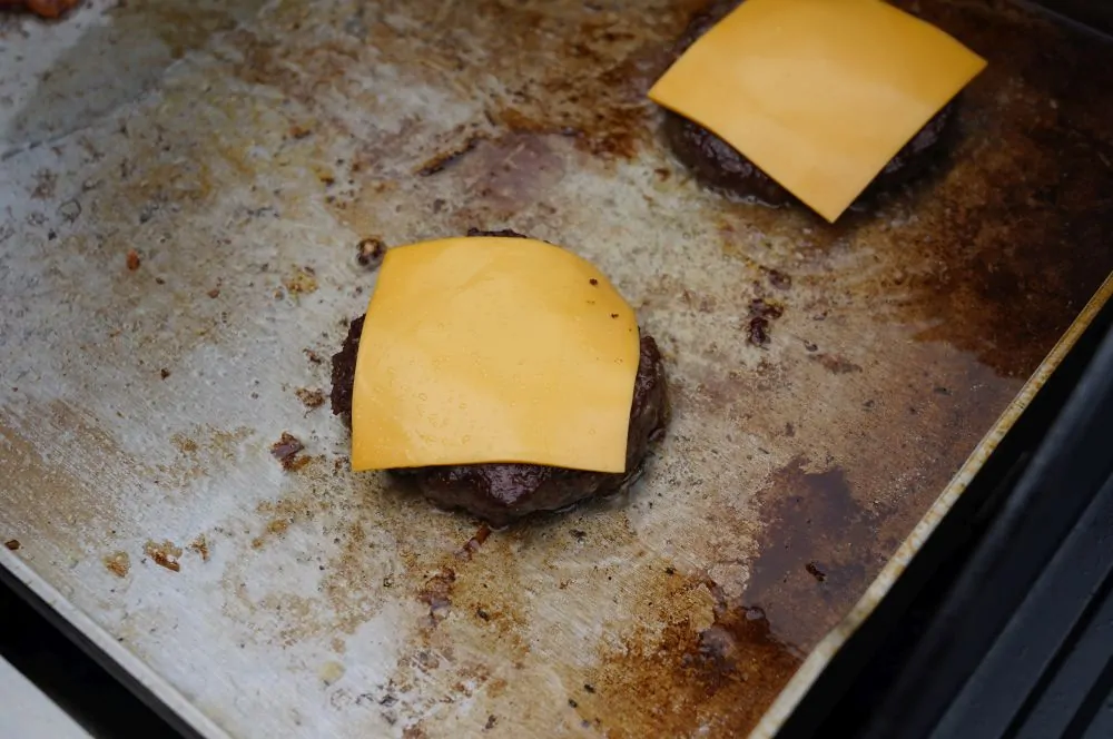 Die Patties werden mit Käse belegt