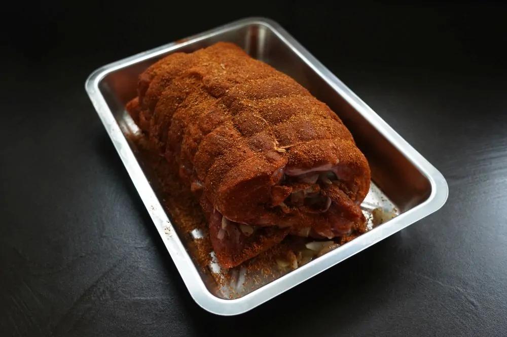 Der aufgerollte Braten wird gebunden und gewürzt